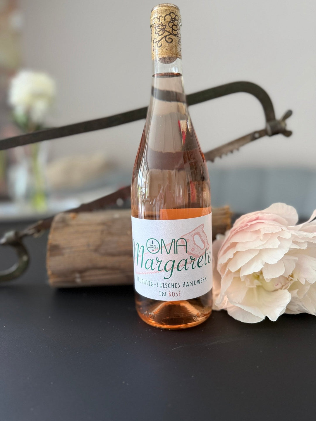 Weinwunder - Rosé Oma Margarete vor Deko mit Rose und Säge